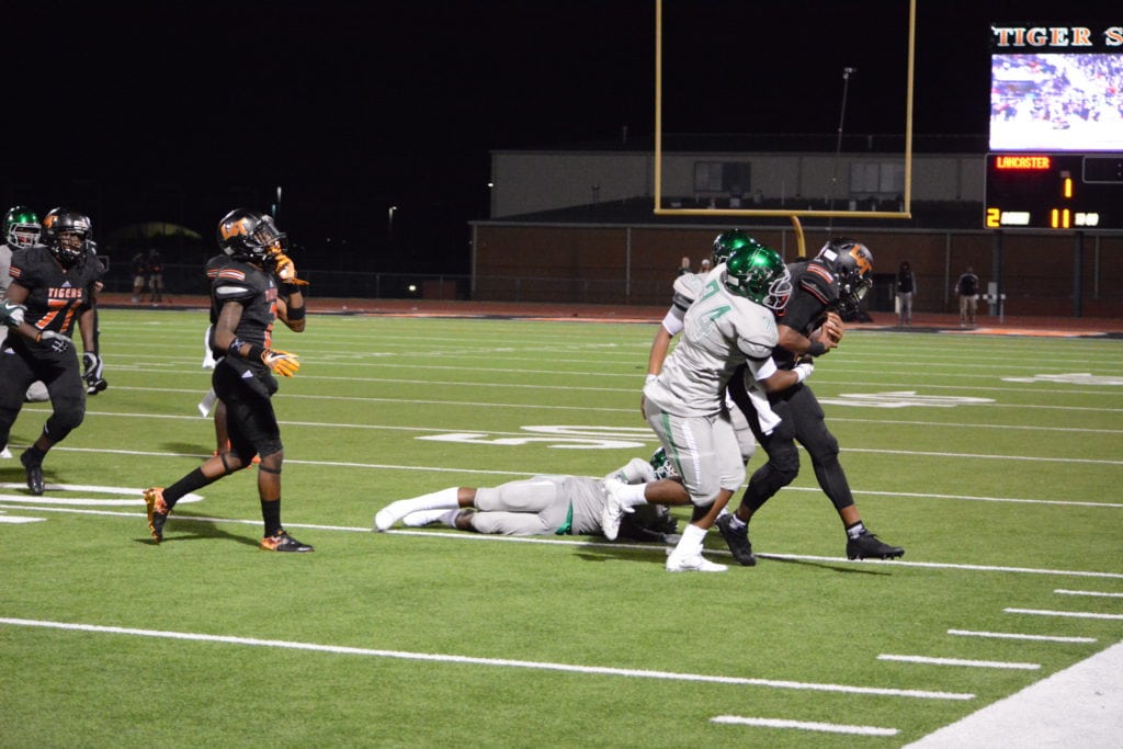 Lancaster High School Quarterback Trevor Hatton has three Waxahachie Indian defenders tackling him during the second quarter of the the teams' game October 28 at Beverly D. Humphrey Tiger Stadium. The Lancaster Tigers defeated the Waxahachie Indians 42-35. (Joshua Bustamante/Lancaster High School)