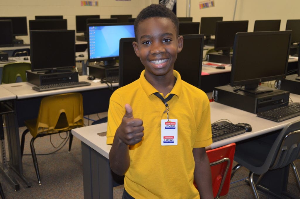 West Middle School student receives 'I Voted' sticker after casting online ballot. 