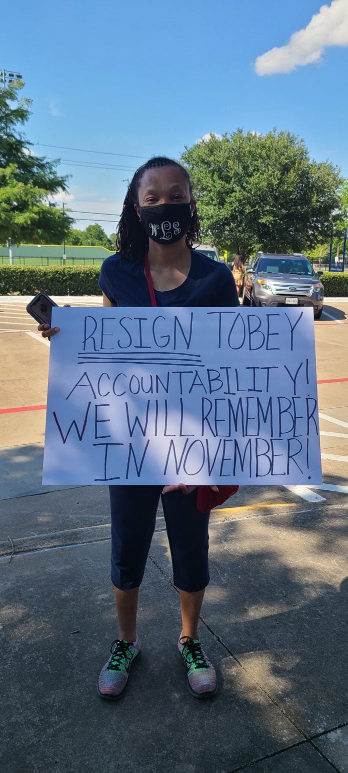 Holding sign at MISD Board Meeting teen holding sign