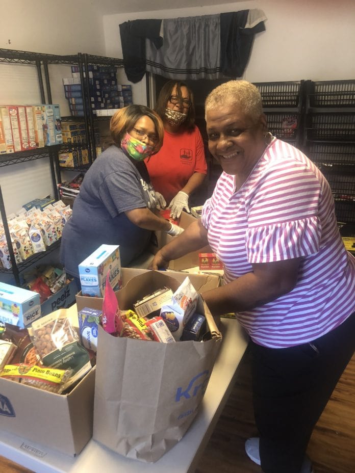 ladies pack food bags at food pantry