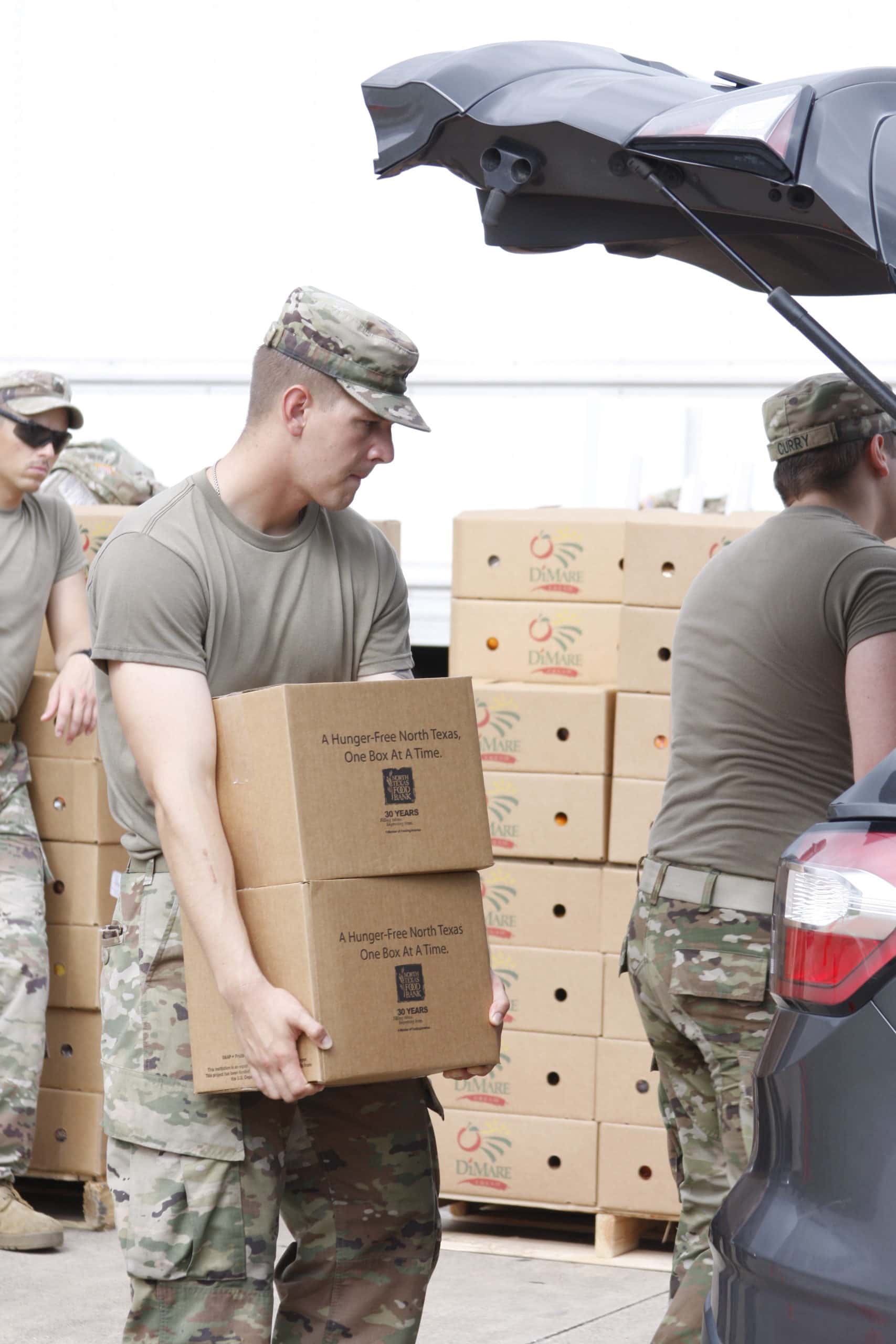 National guardsmen carrying box of food