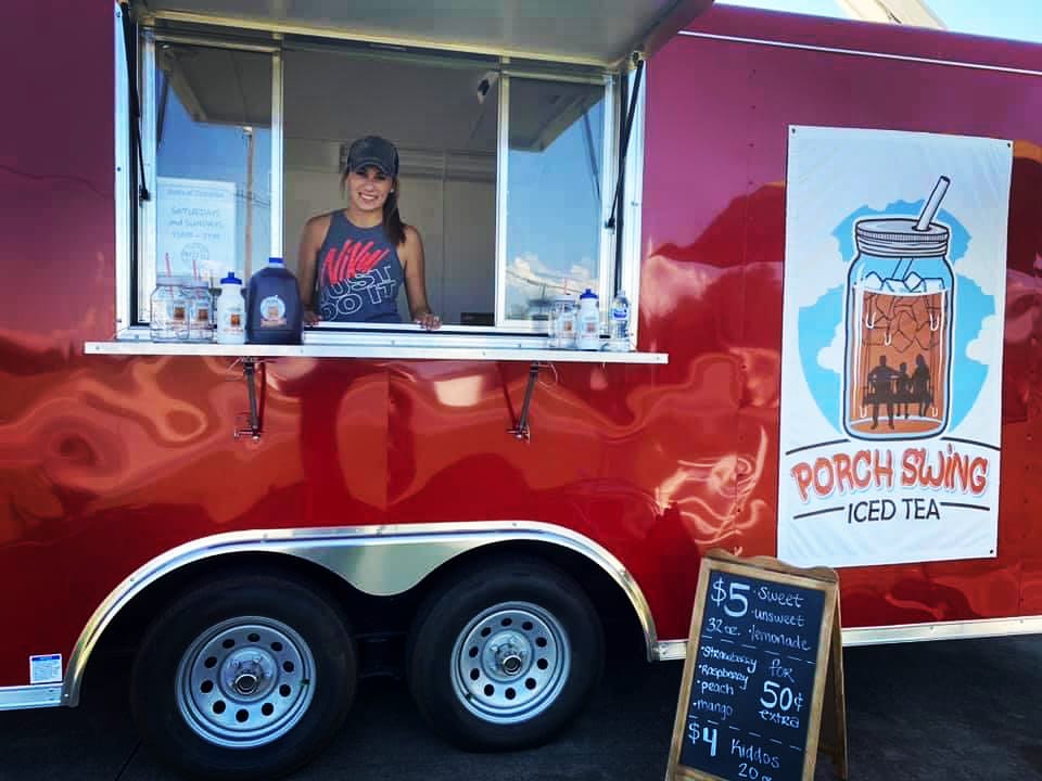 woman in window of porch swing tea trailer