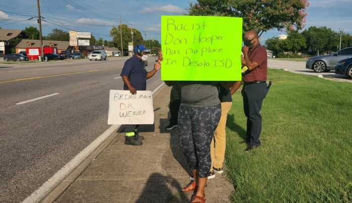 lady holding a sign protesting Don Hooper