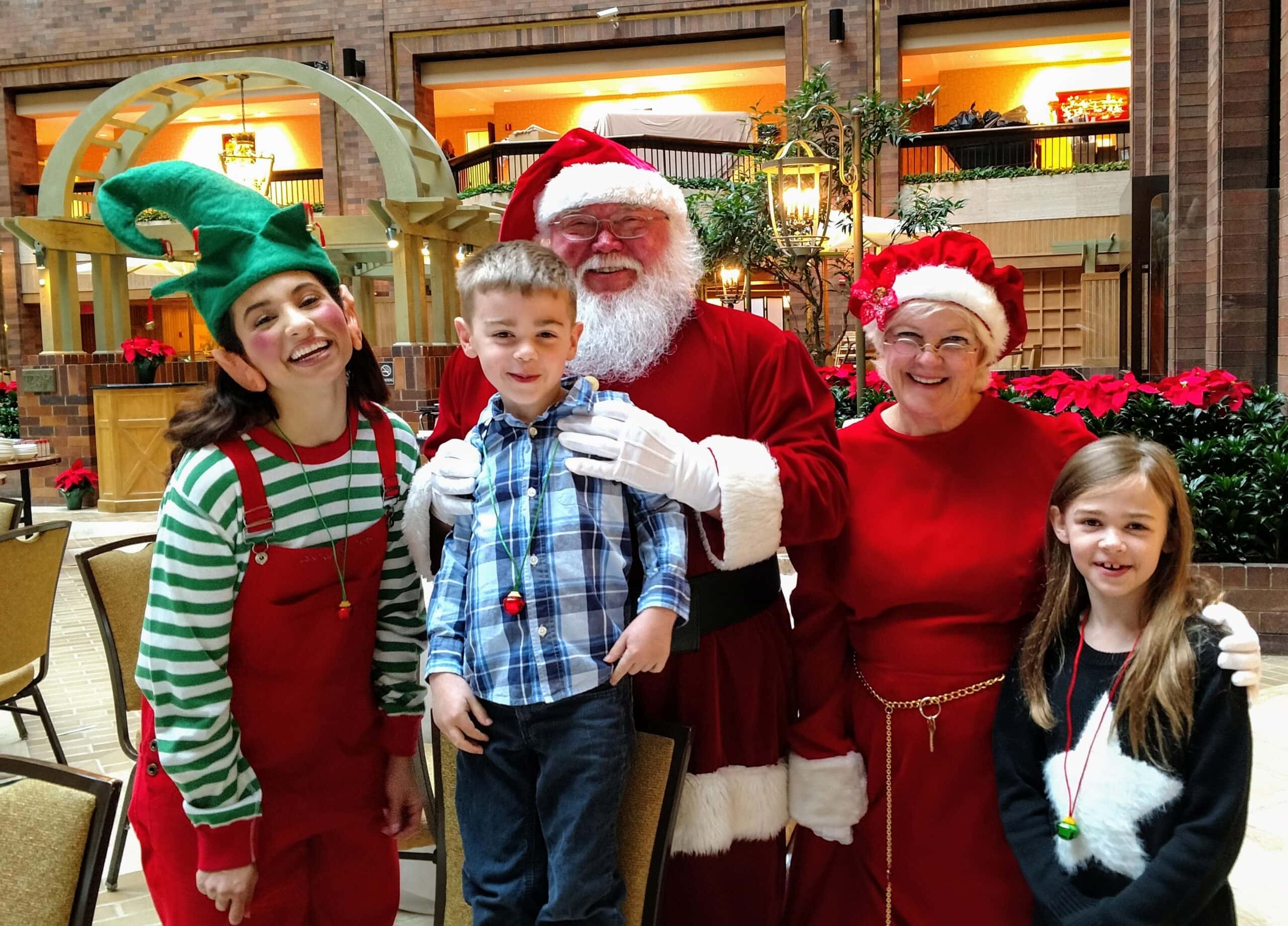 Kids with Santa Mrs Claus and an elf