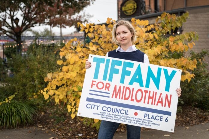 Tiffany Carra holding campaign sign