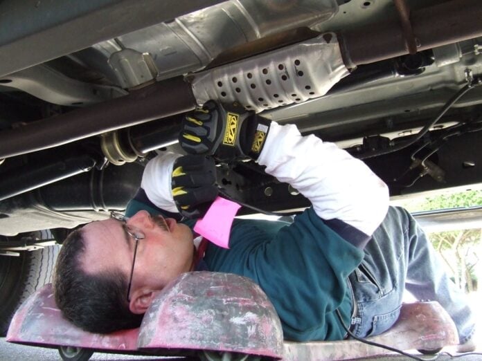 mechanic working on catalytic converter