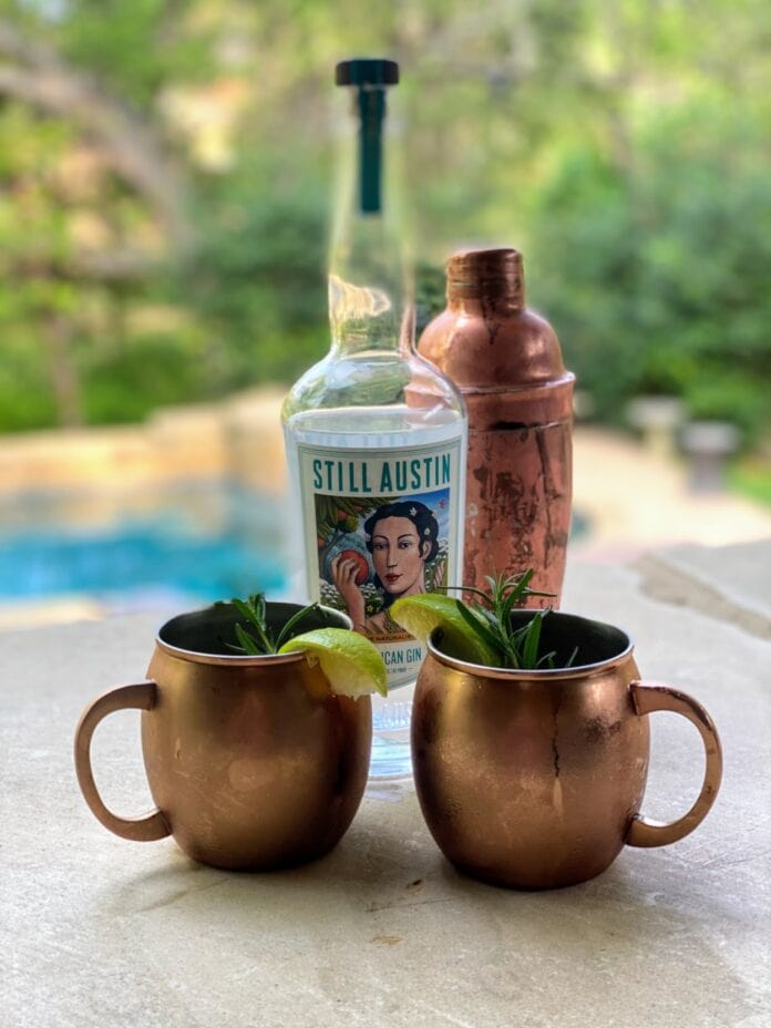 Copper mugs with gin bottle