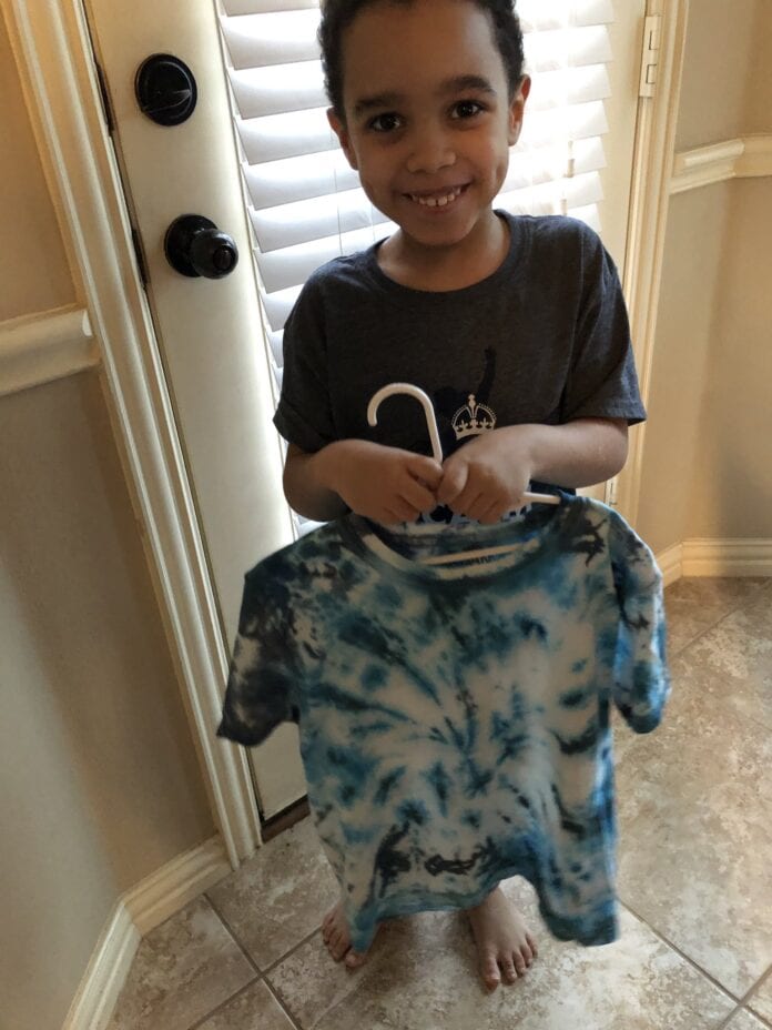 kid holding tye dye tshirt