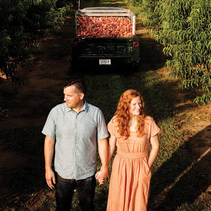 Stephen and jessica Rose stand in peach orchard