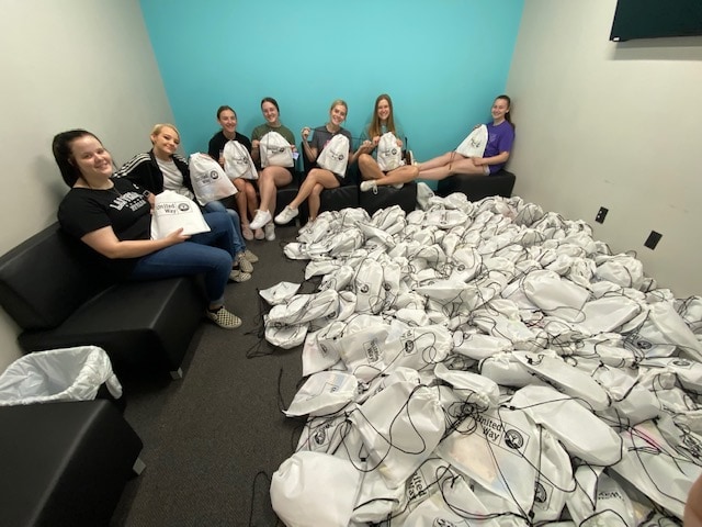students with stack of bags