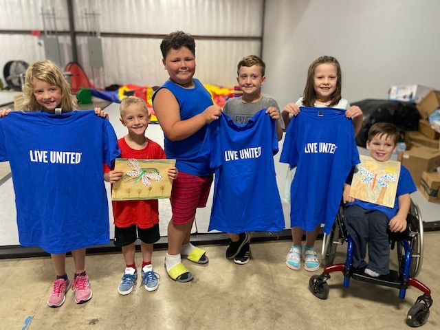 Kids holding t-shirts