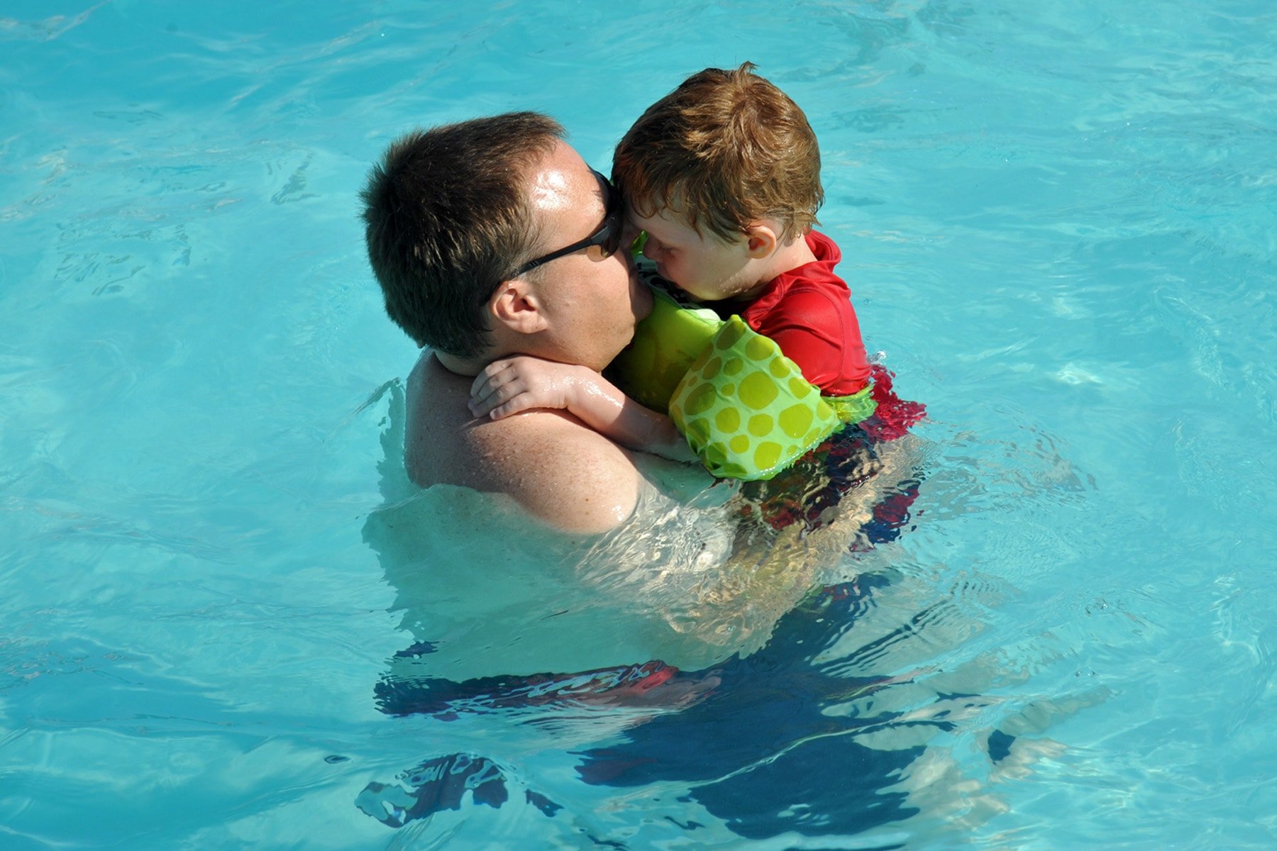 man holding child in pool