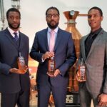 Bourbon Tourism Expands in Louisville The Brough Brothers holding bottles of bourbon