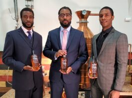 The Brough Brothers holding bottles of bourbon