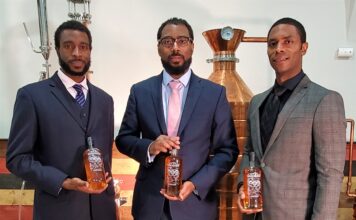 Bourbon Tourism Expands in Louisville The Brough Brothers holding bottles of bourbon