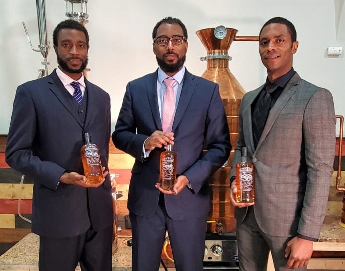 The Brough Brothers holding bottles of bourbon