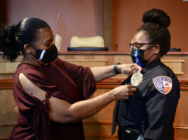 woman placing badge on Officer