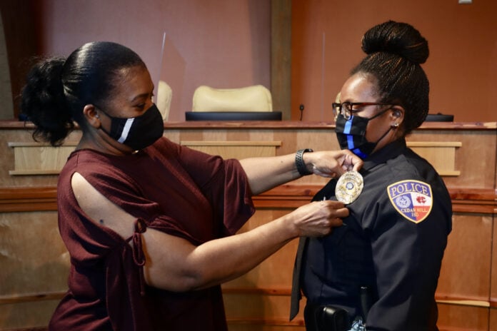 woman placing badge on Officer