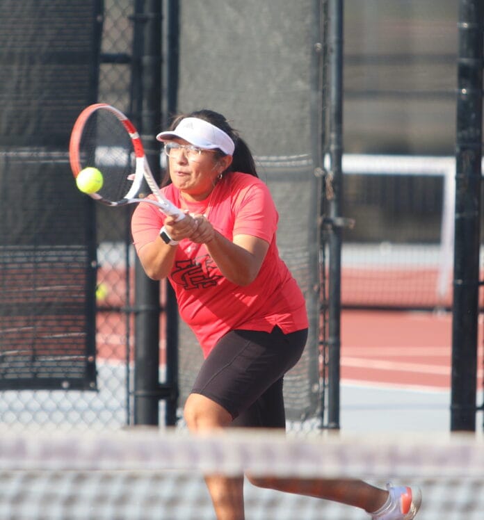 tennis player hitting ball