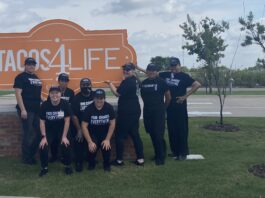 Tacos 4 Life staff in front of sign