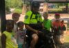 Readers Choice Police Officer of the Year is Happy To Be in Mansfield Police officer on motorcycle with children