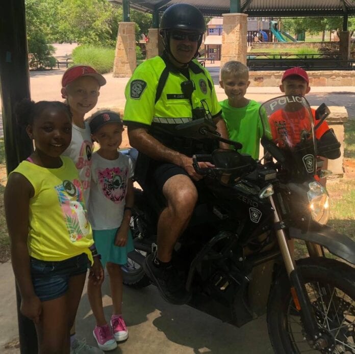 Police officer on motorcycle with children