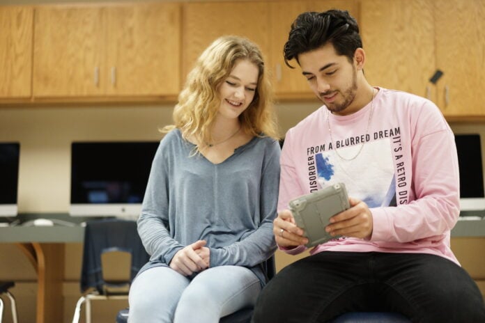 boy and girl sitting next to each other