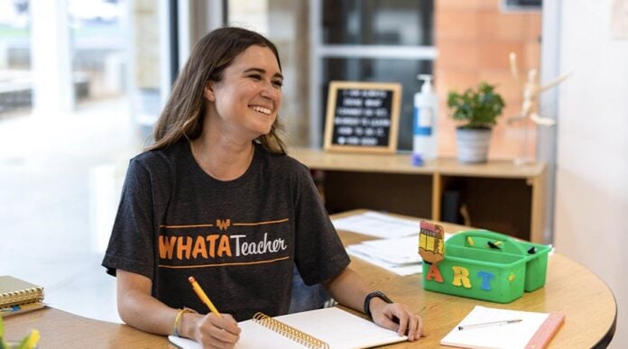 woman wearing whatateacher shirt