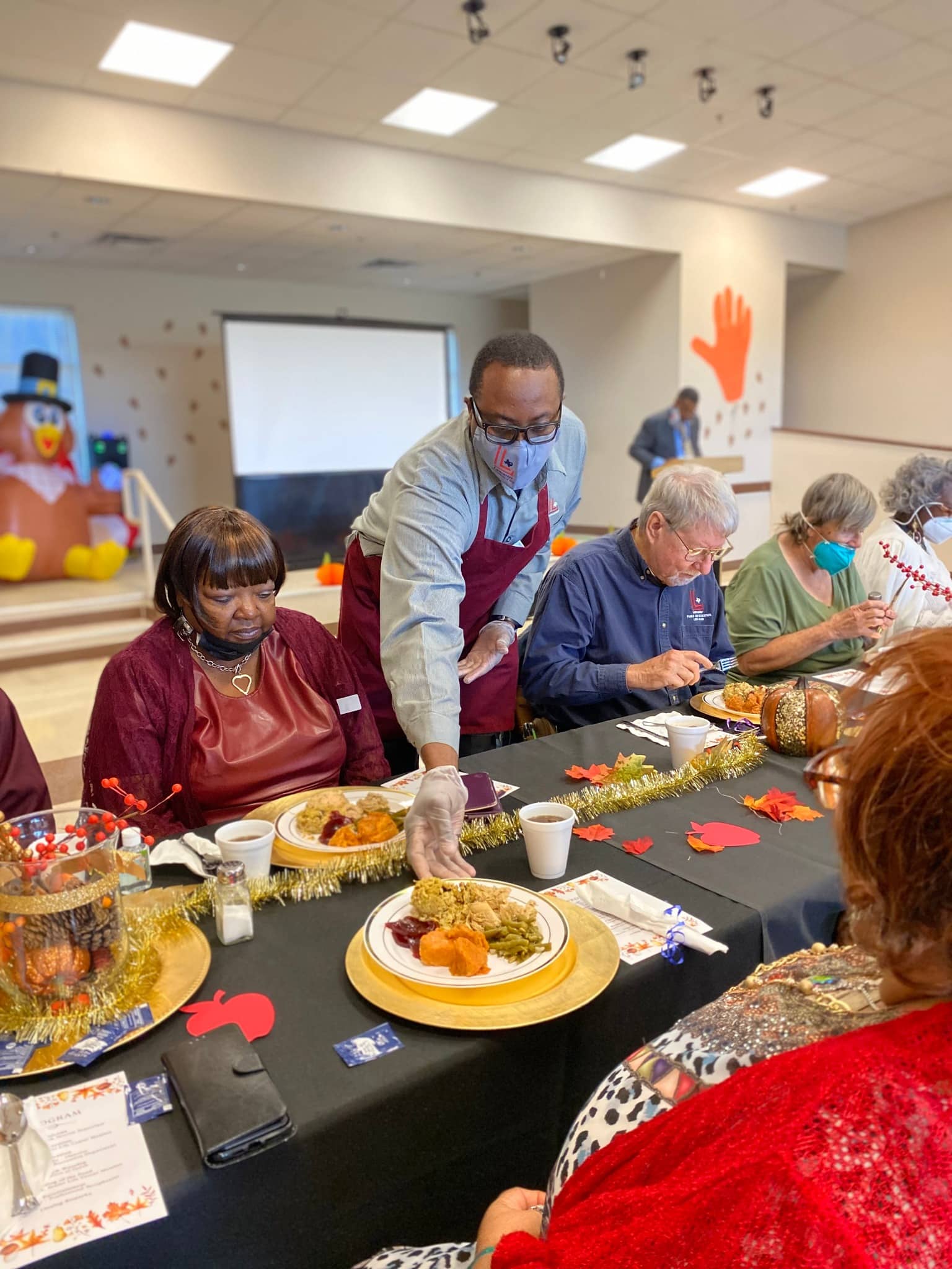 man serving food to seniors