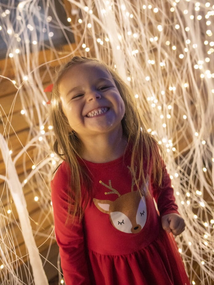 smiling girl with white lights behind her