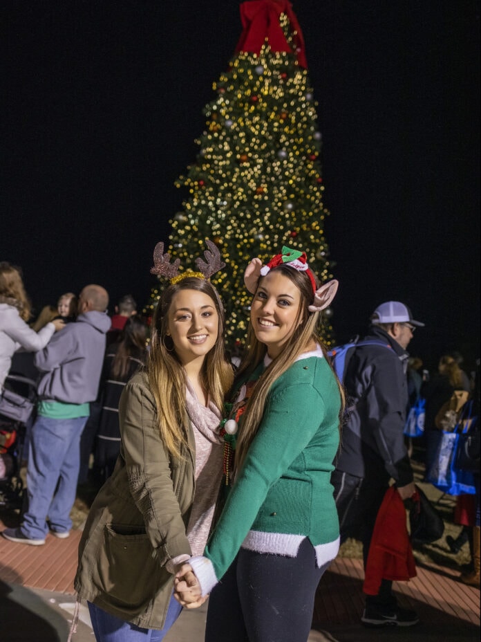 two ladies in front of Christmas tree