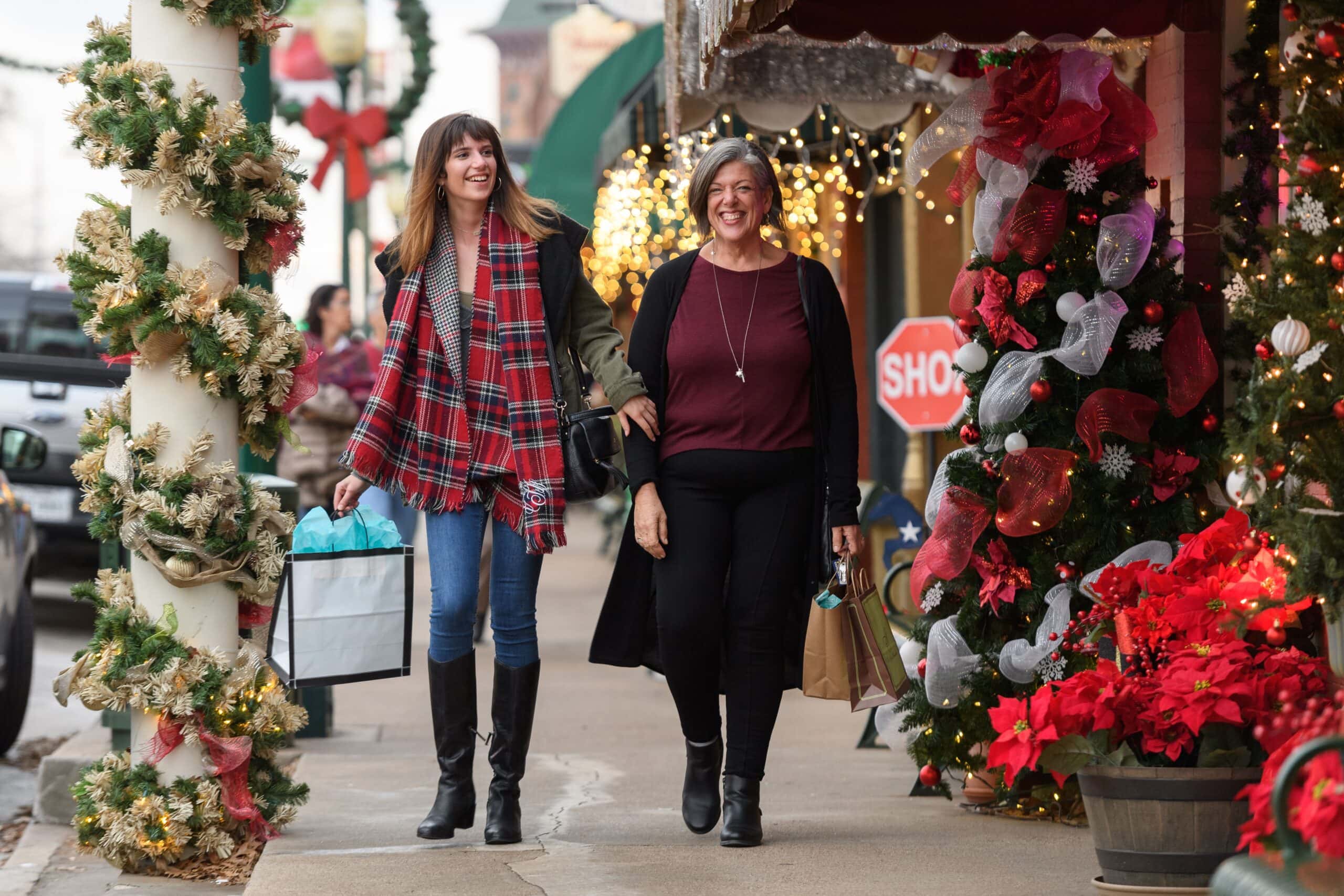 women on sidewalk with shopping bags