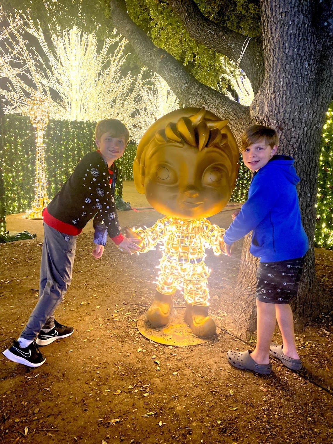 boys pose with elf statue