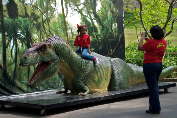 girl sitting on dinosaur