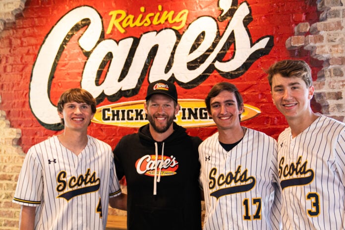 Clayton kershaw in front of Raising Cane's sign