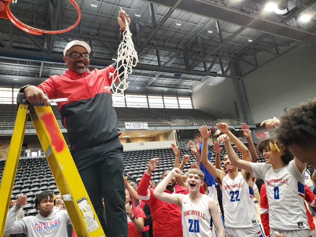 Coach holds basketball net