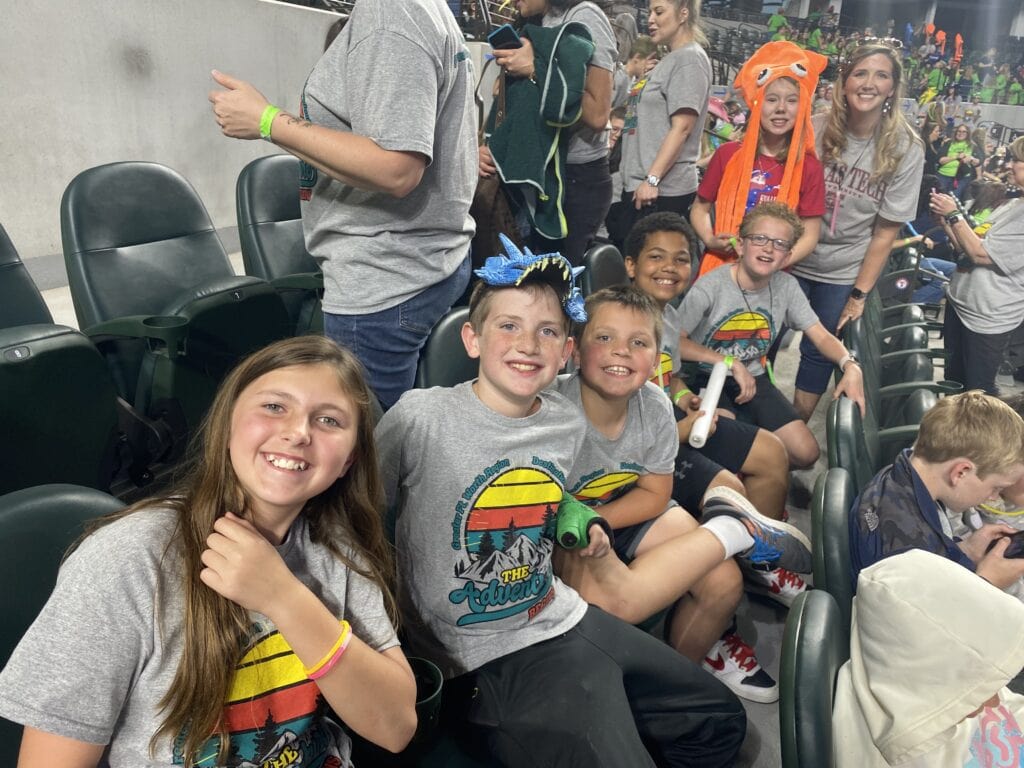 group of kids seating in stadium seats