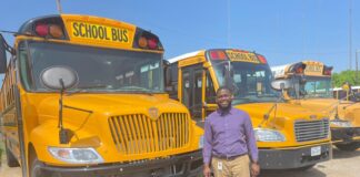 New Cedar Hill ISD Bus Cameras Provide Extra Safety For Riders & Drivers man in front of parked school buses
