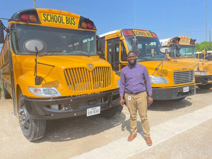 man in front of parked school buses