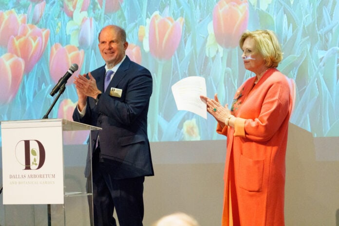 Man at podium with woman clapping hands