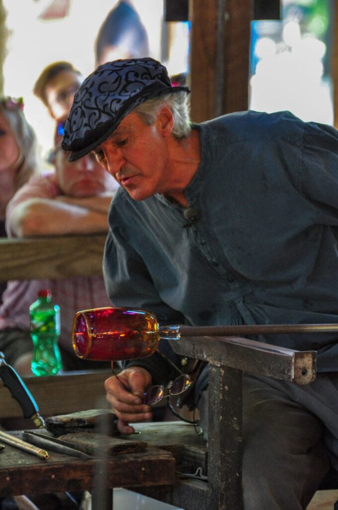 man blowing glass