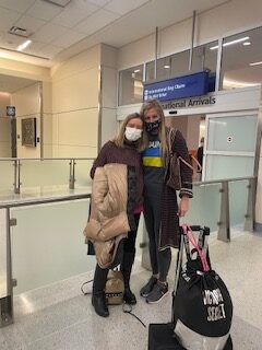 two ladies at airport wearing masks