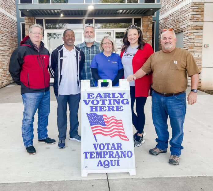 four men and two ladies by early voting sign