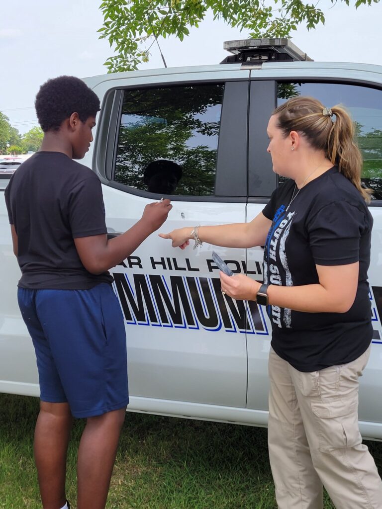 Cedar Hill Police truck with teen learning to fingerprint