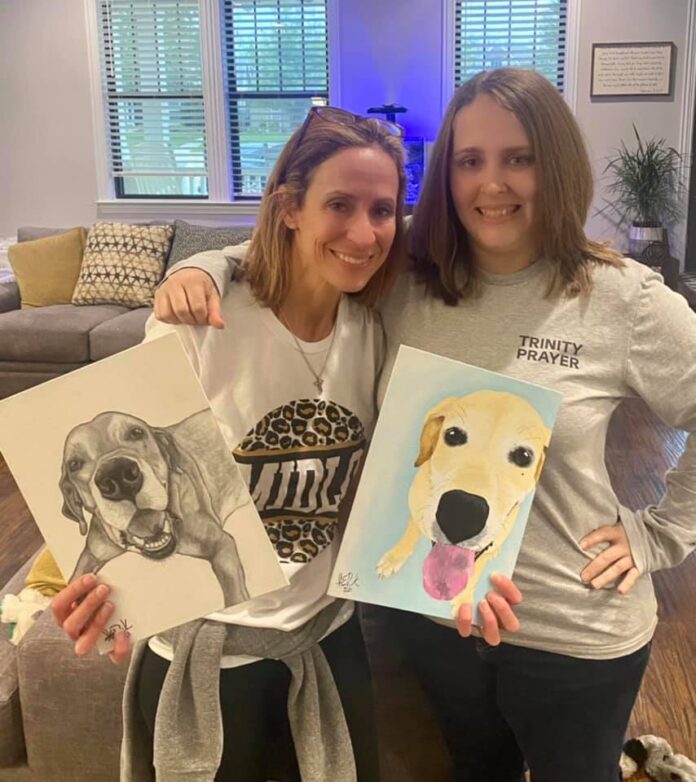 Dantia and Ashley with portraits of Bo the Lab - comissioned pieces Two ladies posing with pet portraits