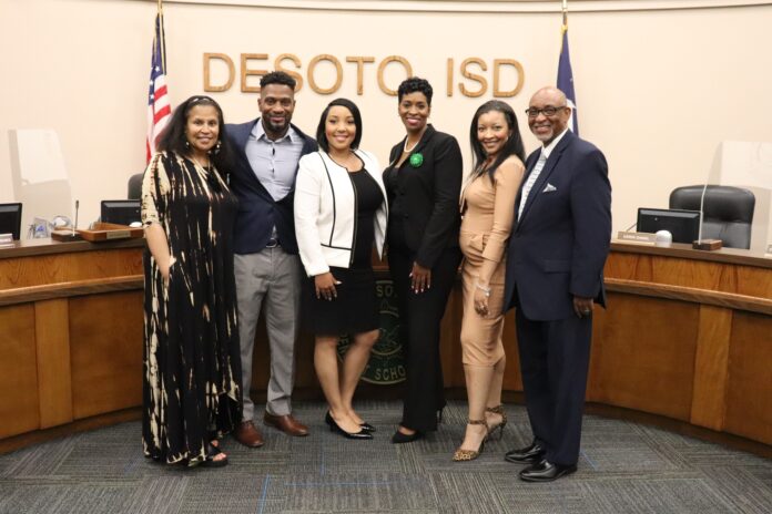 ladies and gentleman standing in front of DeSoto ISD letters