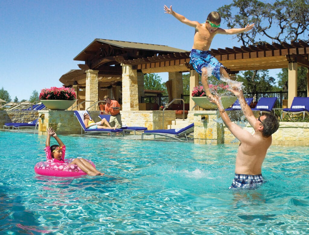 family playing in pool