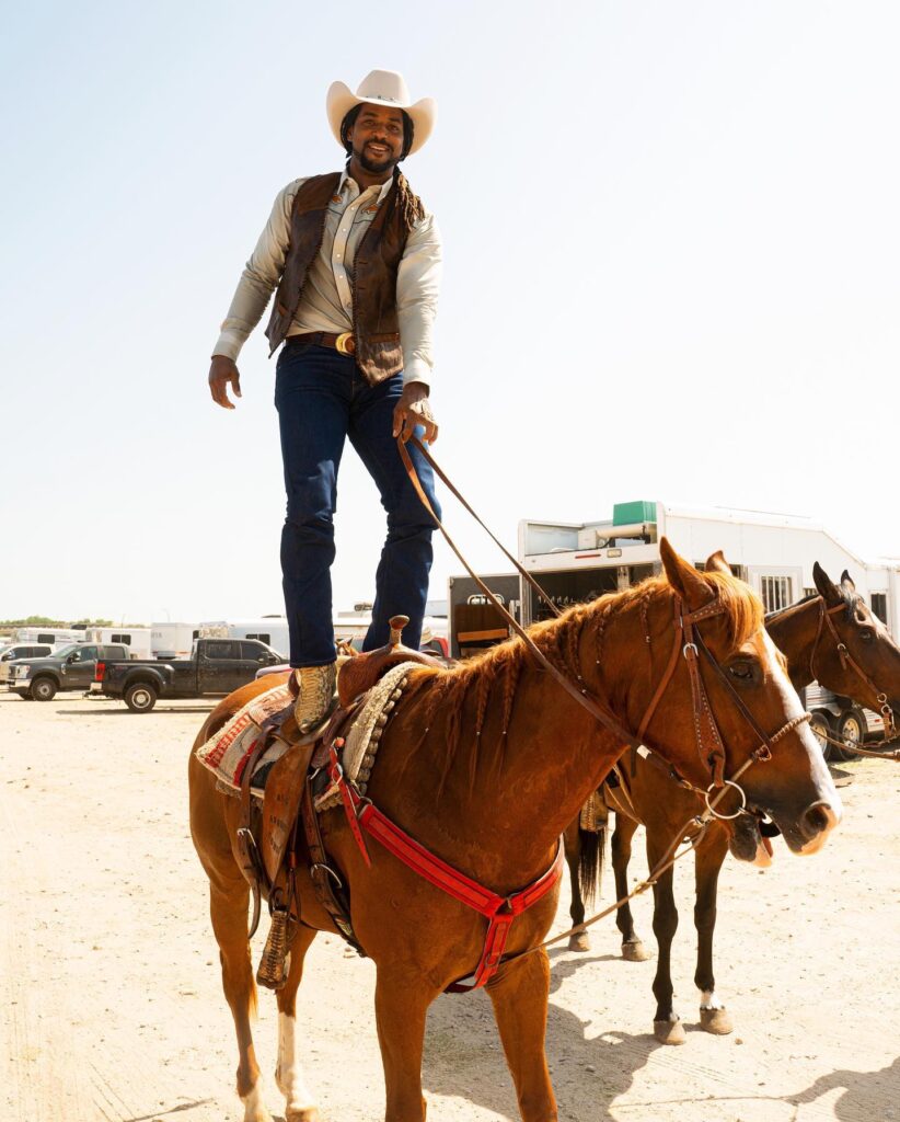 cowboy stands on horse