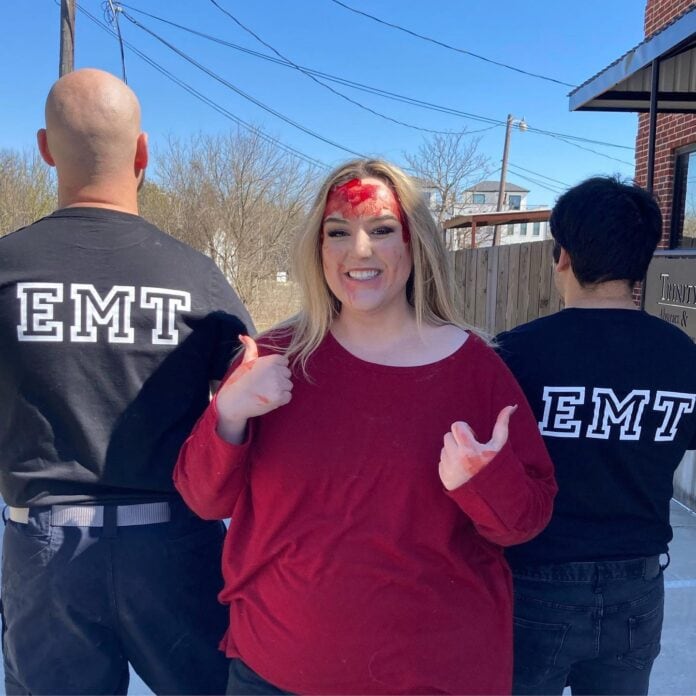 Girl standing next to EMTs