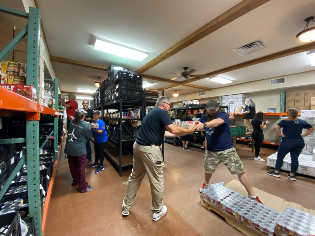 volunteers load food on pantry shelves